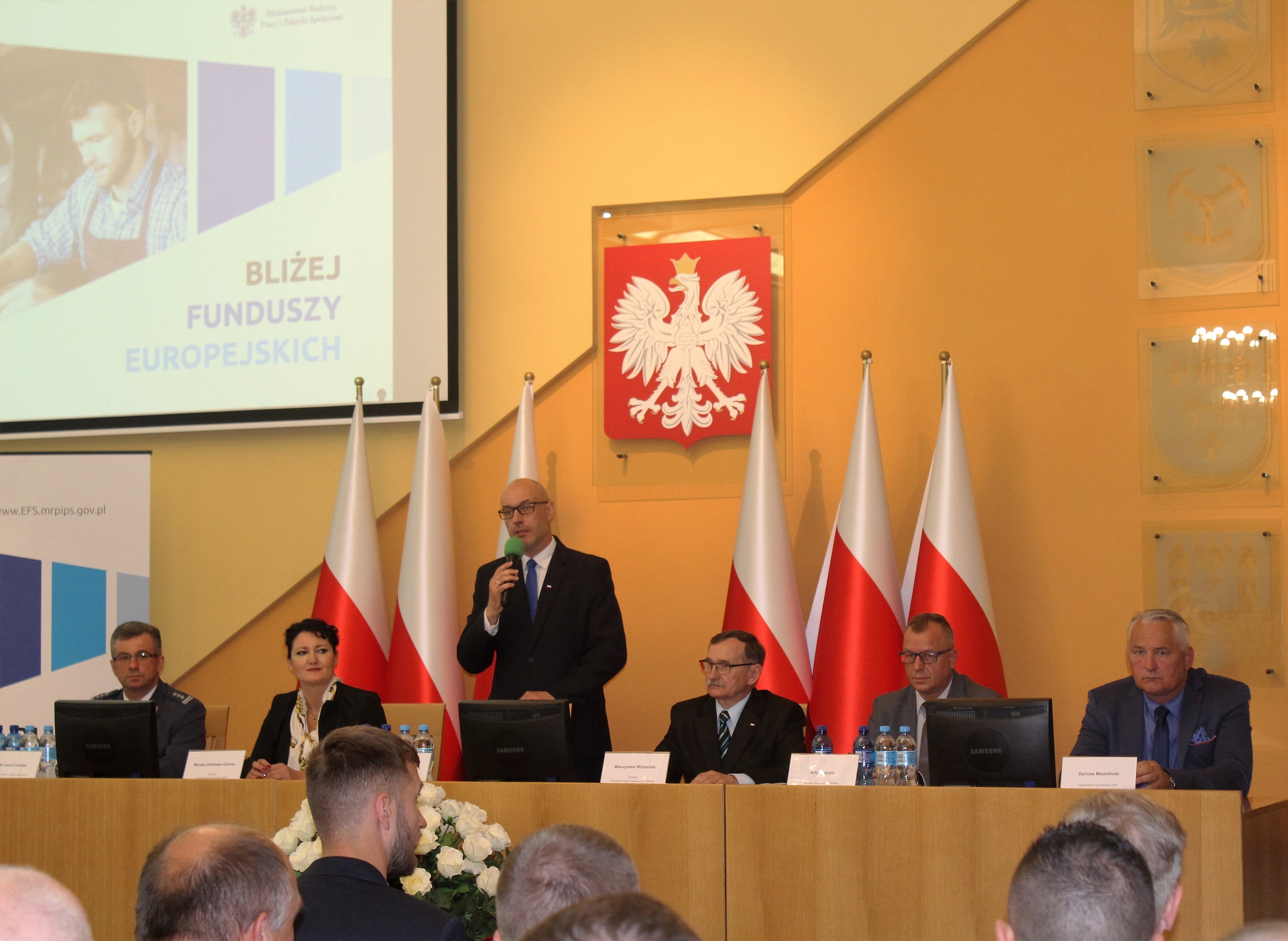 Powitanie gości przez Wojewodę Opolskiego Adriana Czubaka. Na zdjęciu od lewej: Dyrektor Okręgowy Służby Więziennej w Opolu płk Leszek Czereba, Dyrektor Departamentu Wdrażania Europejskiego Funduszu Społecznego Monika Zielińska- Choina, Wojewoda Opolski Adrian Czubak, Dyrektor Wydziału Polityki Społecznej i Zdrowia Opolskiego Urzędu Wojewódzkiego Mieczysław Wojtaszek, Opolski Wicekurator Oświaty Artur Zapała, Wojewódzki Komendant OHP w Opolu Dariusz Medoliński